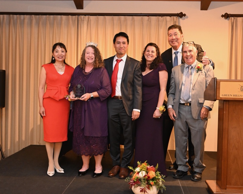 Bob Nguyen on stage at the Millbrae Person of the Year award ceremony beside the honoree holding her award and other guests