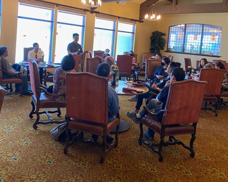 Bob Nguyen standing to speak to a seated audience at a Millbrae community event