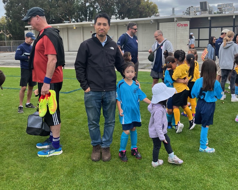 Bob Nguyen on the field at Millbrae AYSO soccer Saturday with his daughters, one in a blue team uniform
