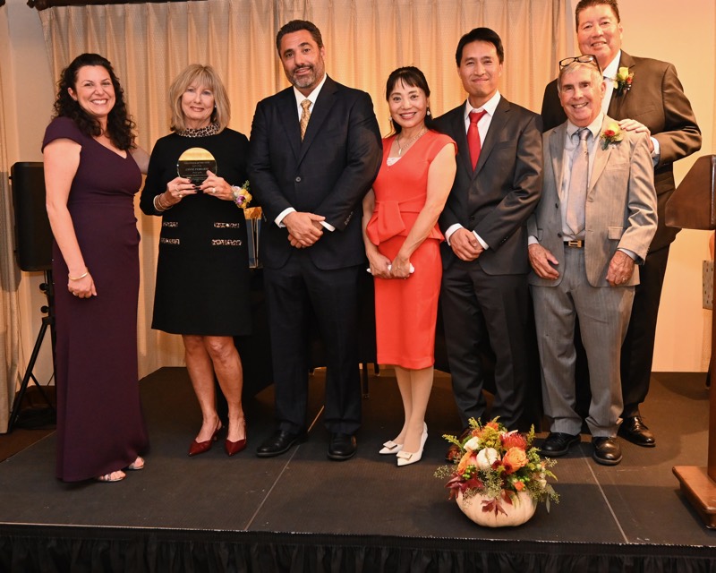 Bob Nguyen on stage at the Millbrae Person of the Year ceremony with an award recipient and other guests